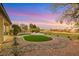 Backyard featuring manicured grass, a desert landscape, and stunning sunset views at 4718 Atlantico St, Las Vegas, NV 89135