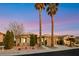 Inviting single-story home with manicured landscaping, towering palm trees, and a charming facade, under a colorful twilight sky at 4718 Atlantico St, Las Vegas, NV 89135