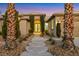 Inviting front entrance with stone pathway, mature palm trees, and a beautifully arched entryway at 4718 Atlantico St, Las Vegas, NV 89135