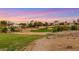 Picturesque golf course with sand traps surrounded by desert vegetation, and luxurious homes in the background, under a vibrant sky at 4718 Atlantico St, Las Vegas, NV 89135