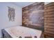 Modern jacuzzi bathtub featuring a wood accent wall, and a brick design pillar at 4871 Reiter Ave, Las Vegas, NV 89108