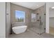 Modern bathroom featuring a freestanding tub, glass shower, and natural light at 5271 Villa Vecchio Ct, Las Vegas, NV 89141