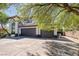 Spacious three-car garage with a wide driveway, complemented by an arched window and front entrance at 5271 Villa Vecchio Ct, Las Vegas, NV 89141