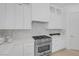 Close-up of modern gas stovetop, backsplash, and white cabinets in a newly renovated kitchen at 5271 Villa Vecchio Ct, Las Vegas, NV 89141