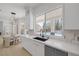 Stylish kitchen with white cabinetry, a black faucet, quartz countertops, and a view of the backyard pool at 5271 Villa Vecchio Ct, Las Vegas, NV 89141