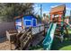 A quaint, custom backyard playset with a wooden deck, slide and playhouse at 5385 Ravendale Cir, Las Vegas, NV 89120