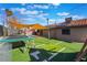 Wide-angle view of the backyard featuring artificial turf, landscaping and a trampoline at 5385 Ravendale Cir, Las Vegas, NV 89120