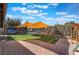 Spacious backyard with a large awning, artificial turf and a play structure at 5385 Ravendale Cir, Las Vegas, NV 89120