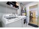 Well-lit laundry room featuring a modern washer and dryer set with built-in shelving for storage at 5385 Ravendale Cir, Las Vegas, NV 89120