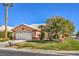 Inviting front exterior of home, showcasing a lush lawn, mature trees, and a classic two-car garage at 5452 Green Palms St, Las Vegas, NV 89130