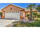 Home's facade featuring a two-car garage, desert landscaping, and a well-maintained lawn at 5452 Green Palms St, Las Vegas, NV 89130