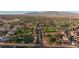 Expansive aerial view of the neighborhood featuring a golf course, pond, and mountain backdrop at 5601 Cavalier Cir, Las Vegas, NV 89130