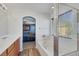 Bright bathroom featuring a soaking tub, shower, and an arched bedroom entrance at 5976 Ancona Dr, Las Vegas, NV 89141