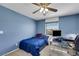 Blue bedroom with ceiling fan, window, and work desk with comfortable bed at 5976 Ancona Dr, Las Vegas, NV 89141