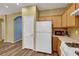 A kitchen featuring wood cabinets, white appliances, and hardwood-style flooring at 5976 Ancona Dr, Las Vegas, NV 89141