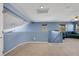 Spacious carpeted loft area with blue walls, a ceiling fan, two windows and a partial view of a green sofa at 5976 Ancona Dr, Las Vegas, NV 89141