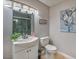 Well-lit bathroom with a single sink vanity, tile floors, and a tiled shower with glass door at 5990 Mcleod Dr, Las Vegas, NV 89120