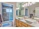 Modern bathroom featuring double sinks, a stone tiled shower, and contemporary lighting at 5990 Mcleod Dr, Las Vegas, NV 89120