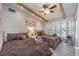 Bright bedroom featuring two beds, ceiling fan, and a large window overlooking the yard at 5990 Mcleod Dr, Las Vegas, NV 89120