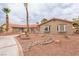 Charming single-story home with a red tile roof, desert landscaping, and a circular driveway with mature palm trees at 5990 Mcleod Dr, Las Vegas, NV 89120