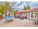 Outdoor patio with a ping pong table, dining set, and comfortable lounge seating with red cushions at 5990 Mcleod Dr, Las Vegas, NV 89120