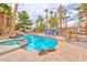 Inviting backyard pool and spa with mature palm trees, stone accents, and plenty of space for relaxation and recreation at 5990 Mcleod Dr, Las Vegas, NV 89120