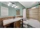 Bathroom featuring a tub with shower, single sink vanity and decorative fixtures at 604 Canyon Rd, Henderson, NV 89002