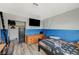 Bedroom featuring a large TV, wood-look floors and blue accent wall at 604 Canyon Rd, Henderson, NV 89002