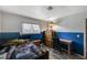 Bedroom with blue accent wall, wood-look floors, a desk and a dresser at 604 Canyon Rd, Henderson, NV 89002