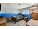 A blue-painted bedroom featuring wood-look floors, a desk, and natural light at 604 Canyon Rd, Henderson, NV 89002