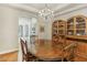 Elegant dining room features a wooden table with chairs, chandelier lighting, and decorative wooden china cabinets at 613 Pinnacle Heights Ln, Las Vegas, NV 89144