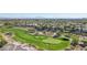 Aerial view of a lush green golf course surrounded by desert landscape and luxury homes in the background under a clear blue sky at 613 Pinnacle Heights Ln, Las Vegas, NV 89144