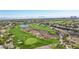 Aerial view of a lush green golf course with sand traps, a lake, and luxury homes in the background under a clear blue sky at 613 Pinnacle Heights Ln, Las Vegas, NV 89144