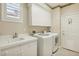 Well-equipped laundry room with a sink, countertop, storage cabinets, washer, and dryer at 613 Pinnacle Heights Ln, Las Vegas, NV 89144