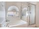 Bright bathroom features a soaking tub with a window and a separate glass-enclosed shower at 6608 Ringbill Ct, North Las Vegas, NV 89084