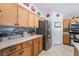 Kitchen featuring stainless steel appliances, wooden cabinetry and tile backsplash at 6608 Ringbill Ct, North Las Vegas, NV 89084