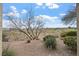 Backyard featuring desert landscaping and partial views of the golf course and blue skies at 704 Peachy Canyon Cir # 101, Las Vegas, NV 89144