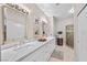 Bathroom with double sinks, quartz counters, framed mirrors, and elegant lighting fixtures at 704 Peachy Canyon Cir # 101, Las Vegas, NV 89144