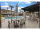 Relaxing poolside with modern outdoor furniture and shade, perfect for community gatherings at 704 Peachy Canyon Cir # 101, Las Vegas, NV 89144