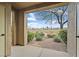 Courtyard view through arched opening showcases the backyard and golf course at 704 Peachy Canyon Cir # 101, Las Vegas, NV 89144