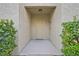 Cozy entryway with a neutral-colored door, surrounded by lush green bushes on either side at 704 Peachy Canyon Cir # 101, Las Vegas, NV 89144