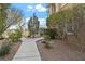 Lush front yard featuring manicured bushes, rock beds, and a winding sidewalk leading to the home at 704 Peachy Canyon Cir # 101, Las Vegas, NV 89144