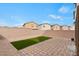 This backyard features a small patch of grass and a stone-laid patio at 7462 Dragonfruit Ave, Las Vegas, NV 89113