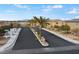 View of the community entrance and paved street with manicured landscaping and palm trees at 7462 Dragonfruit Ave, Las Vegas, NV 89113