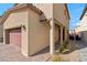 Home exterior showcasing a two-car garage, covered entry, and desert-friendly landscaping at 7462 Dragonfruit Ave, Las Vegas, NV 89113