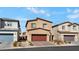 View of a home with neutral-colored exterior, two-car garage, and desert landscaping at 7462 Dragonfruit Ave, Las Vegas, NV 89113