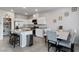 Well-lit kitchen featuring white cabinets, granite counters, stainless steel appliances, a kitchen island, and a dining area at 7462 Dragonfruit Ave, Las Vegas, NV 89113