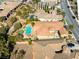 Wide aerial view of a property with a pool, lush landscaping, and a well-kept neighborhood at 77 Chapman Heights St, Las Vegas, NV 89138