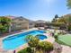 Lush backyard featuring a custom pool and spa, outdoor kitchen, and putting green, perfect for outdoor entertainment at 77 Chapman Heights St, Las Vegas, NV 89138