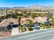 Charming single-story home featuring lush desert landscaping, a two-car garage and mountain views at 77 Chapman Heights St, Las Vegas, NV 89138